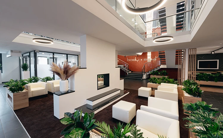 Loungebereich mit Sesseln im Erdgeschoss des Fitness Centers Trudering.