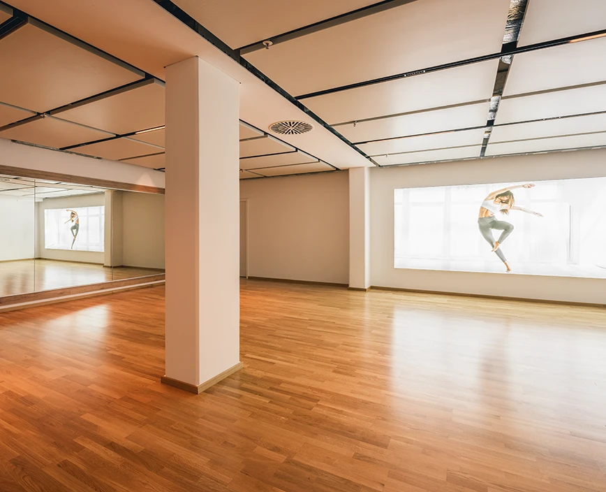 Studio mit Parkettfußboden und Spiegelwand für Kursangebote im Center Theresienhöhe.