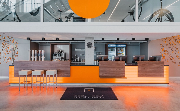 Moderner Empfang mit Check-in und Kundenservice im body + soul Fitnesscenter WERK12 im Werksviertel Mitte.