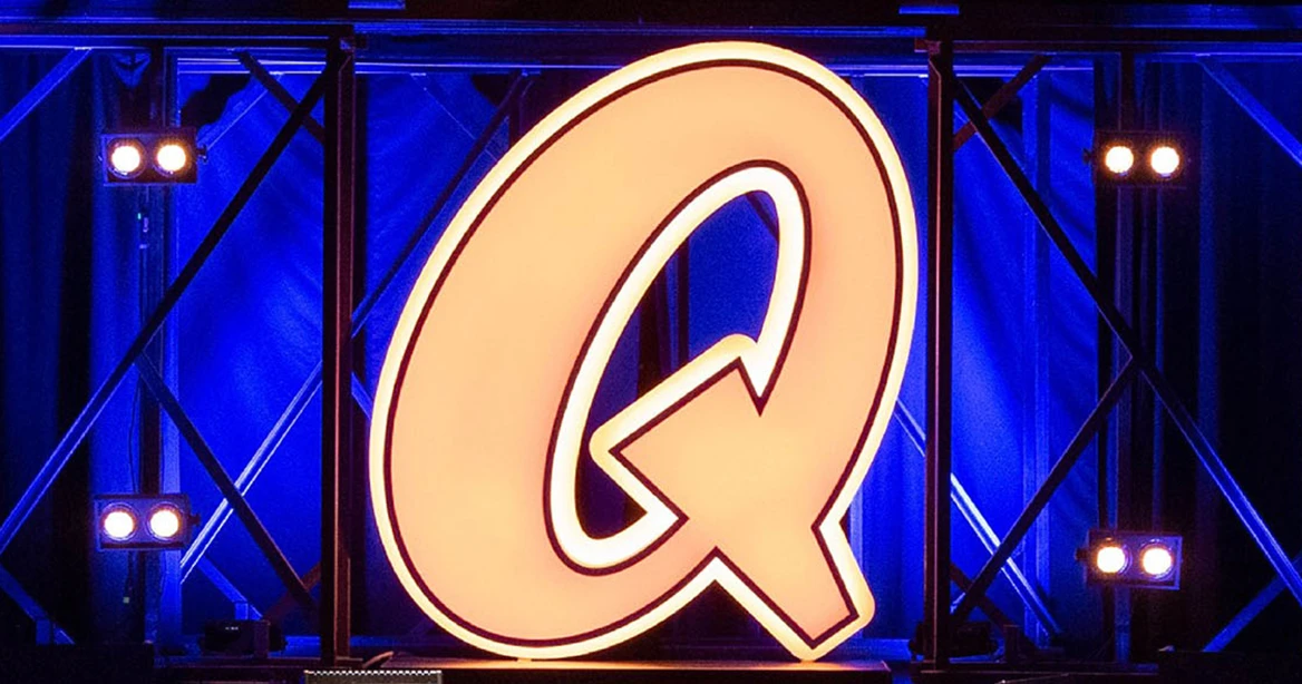 Beleuchtete Bühne des Quatsch Comedy Club mit einem riesigen Leuchtbuchstaben Q.