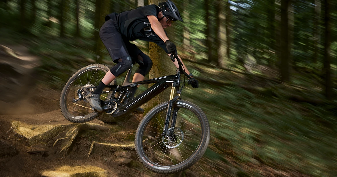 Mountain-Biker fährt Downhill im Wald.