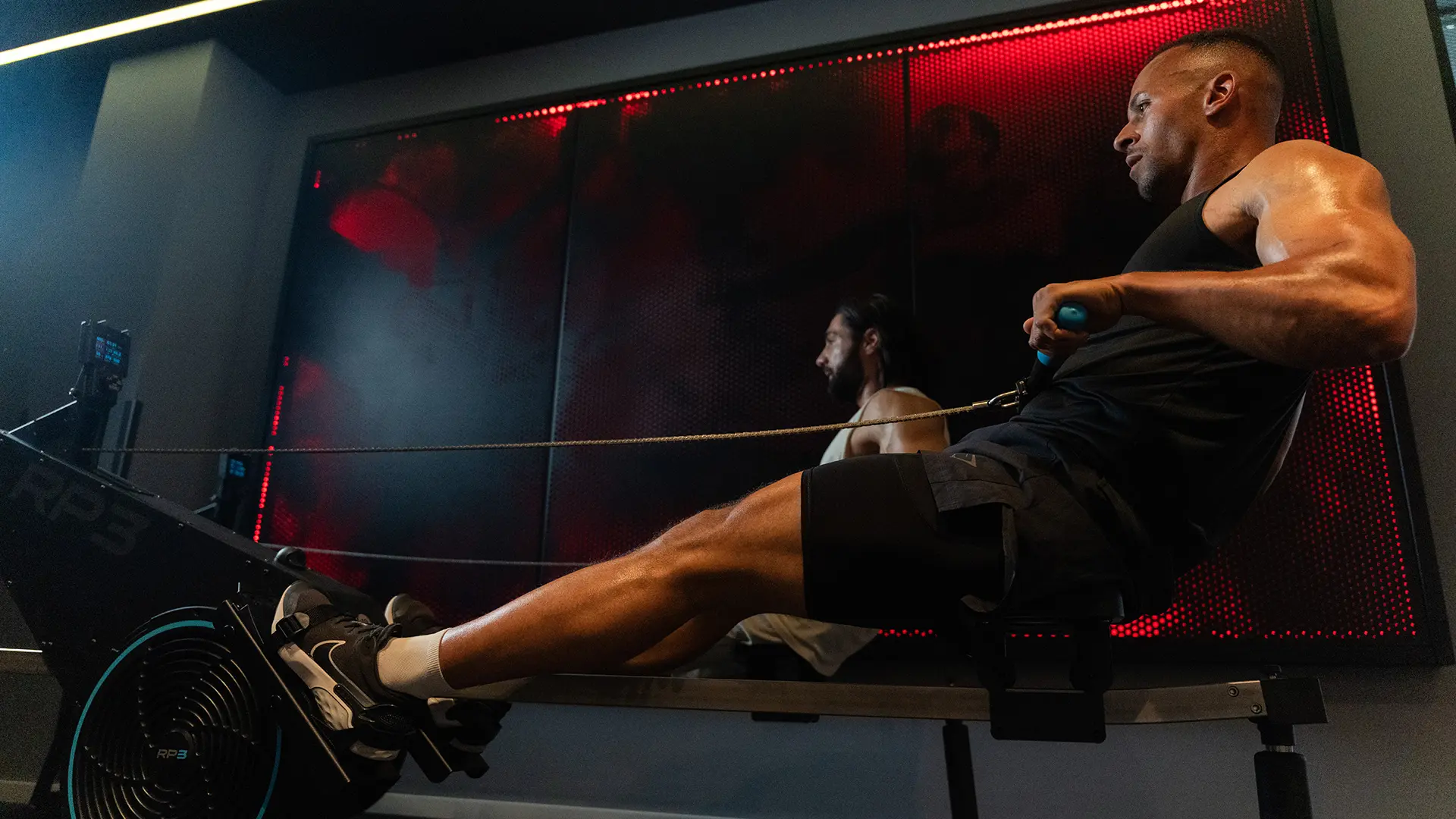Zwei Männer trainieren gemeinsam am Rower.