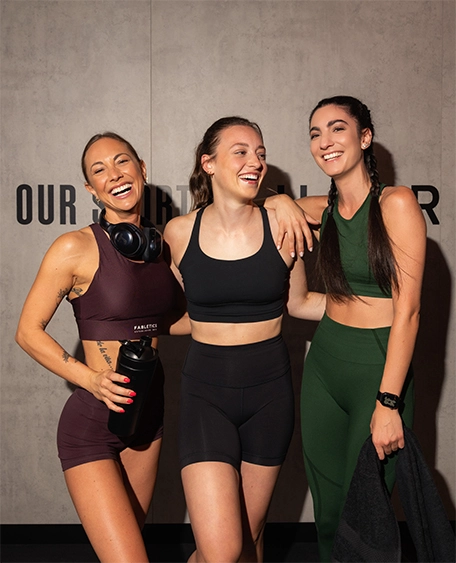 Drei Frauen lachen im Fitnessstudio.