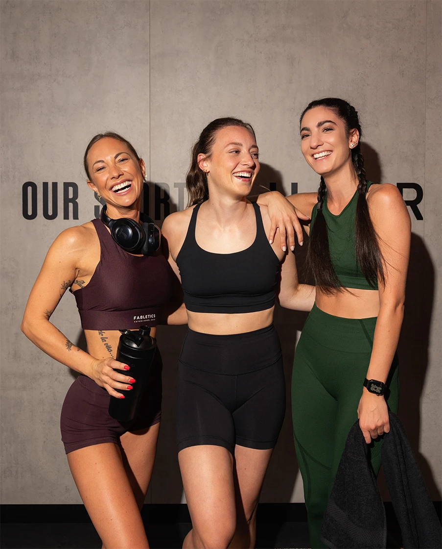 Drei Frauen lachen im Fitnessstudio.
