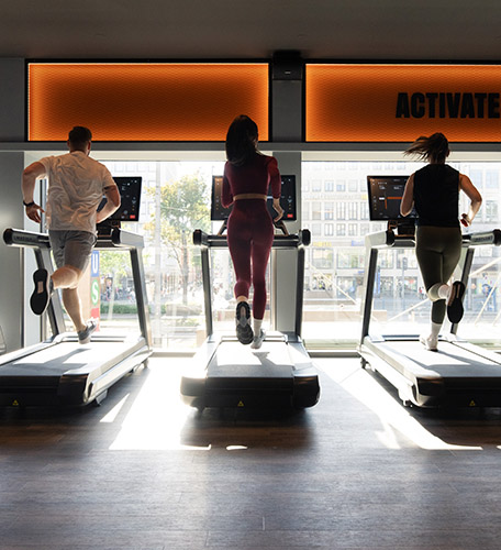 3 Personen auf Laufbändern im Fitnessstudio